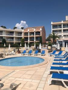 ein Resort mit Liegestühlen und einem Pool in der Unterkunft Duplex vue mer spendide, terrasse piscine jardins parking in Cannes