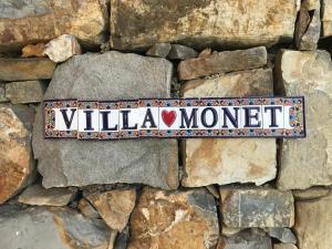 un cartel que dice "Villa Momento en una pared de piedra" en Villa Monet en Bordighera