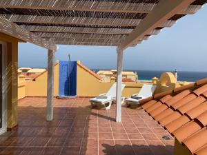 patio z krzesłami i oceanem w tle w obiekcie Casa Vista del Mar 1 w mieście Morro del Jable