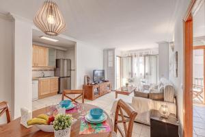 a kitchen and living room with a table and chairs at Mariners in Alcudia