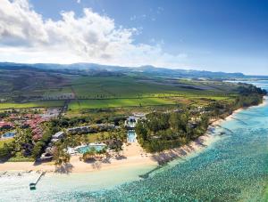a large body of water with palm trees at Outrigger Mauritius Beach Resort in Bel Ombre