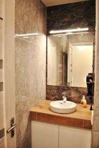 un baño con lavabo y espejo en Apartment at Kirova( A.Polia) 115, en Dnipro