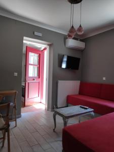 a living room with a red couch and a red door at Elia & Choma in Vathi
