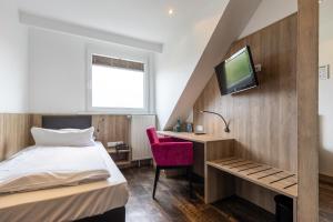 Schlafzimmer mit einem Bett, einem Schreibtisch und einem TV in der Unterkunft Trip Inn Hotel Esplanade in Düsseldorf