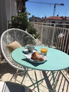 una mesa con un plato de comida y una taza de zumo de naranja en Laura e Christian - Rooms en Grado