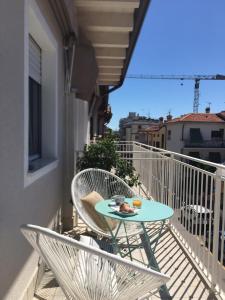 a table and chairs on the balcony of a building at Laura e Christian - Rooms in Grado