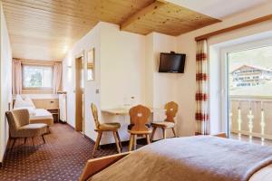 a hotel room with a bed and a table and chairs at Garni Charlotte in Selva di Val Gardena