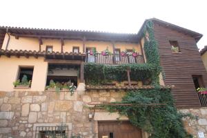 ein Gebäude mit einem Balkon mit Blumen darauf in der Unterkunft Casa Rural La Picota in Valverde de la Vera