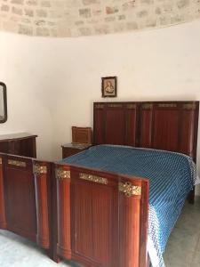 アルベロベッロにあるTrulli della Masseria Staffoneのベッド1台(木製キャビネット付)