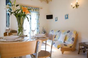 VILLA TIMOKLIA في تسوكالادهيز: غرفة معيشة مع طاولة مع إناء من الزهور