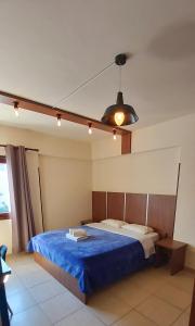 sypialnia z łóżkiem z niebieskim kocem w obiekcie Lakis Court w Larnace