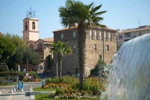 a fountain in front of a building with a clock tower at Park Horizon in Sainte-Maxime