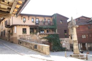 a building with a balcony on the side of a street at Casa Rural La Picota in Valverde de la Vera