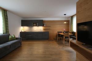ein Wohnzimmer mit einem Sofa und einem Esszimmer in der Unterkunft Residence Rose in Innichen