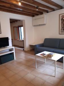 ein Wohnzimmer mit einem blauen Sofa und einem Couchtisch in der Unterkunft Casa Gorne Anzolo in Venedig
