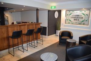 una sala de espera con sillas y un reloj en la pared en Best Western Coachman's Inn Motel, en Bathurst