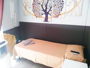 a bedroom with a bed with a tree on the wall at Arena BB in Albenga