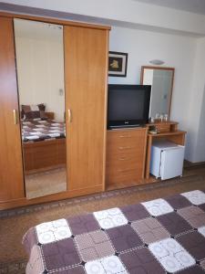 Guest House Georgieva Ravda في رافدا: غرفة معيشة فيها تلفزيون وغرفة نوم