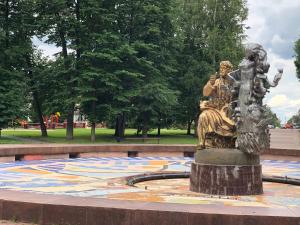 una estatua de una mujer y niños en un suelo de mosaico en un parque en Hotel History, en Velikiy Novgorod