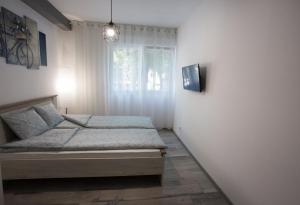 um quarto com uma cama e uma janela em Apartman Petreš em Sombor
