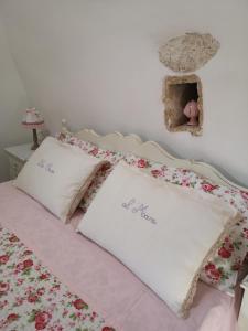 ein Schlafzimmer mit einem Bett mit rosa Blumen drauf in der Unterkunft B&B Corallo in Capilungo