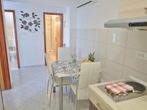 uma cozinha e sala de jantar com mesa e cadeiras em Apartments Lilly by the sea em Barić Draga