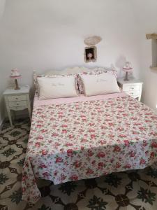 1 Schlafzimmer mit einem Bett mit Blumenbettdecke in der Unterkunft B&B Corallo in Capilungo