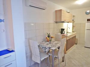 uma cozinha com mesa e cadeiras num quarto em Apartments Lilly by the sea em Barić Draga