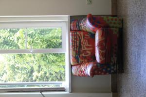 a couch sitting next to a window in a room at C - Punkt Hostel in Ljubljana