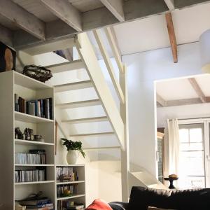 ein Wohnzimmer mit einer Treppe und einem Bücherregal in der Unterkunft Cottage At 31 in Bundanoon
