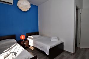 a room with two beds and a blue wall at Light and Bright St Julians Central 1 in St. Julianʼs