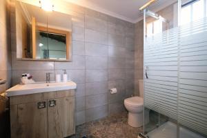 a bathroom with a sink and a toilet and a mirror at Thealassa in Kalliópi