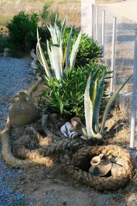 a garden with plants and rocks and a fence at Thealassa in Kalliópi