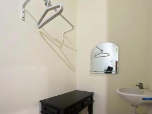 La salle de bains est pourvue d'un lavabo et d'un miroir mural. dans l'établissement RedDoorz Syariah @ Pahlawan Sidoarjo, à Sidoarjo