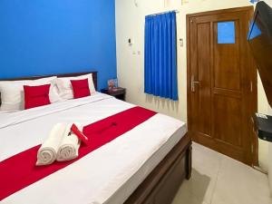 sypialnia z dużym łóżkiem w kolorze czerwonym i niebieskim w obiekcie RedDoorz Syariah @ Pahlawan Sidoarjo w mieście Sidoarjo