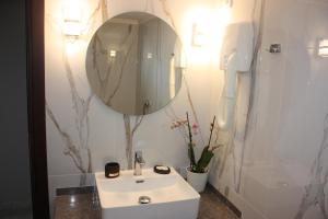bagno con lavandino bianco e specchio di Hotel Cariatis a Nea Kalikratia
