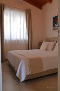 1 dormitorio con 1 cama grande y ventana en Punta Palivi en Mattinata