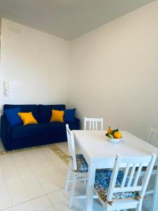 a living room with a table and a blue couch at Casa Amore Positano in Positano