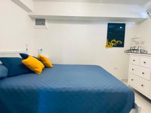 a bedroom with a blue bed with yellow pillows at Casa Amore Positano in Positano