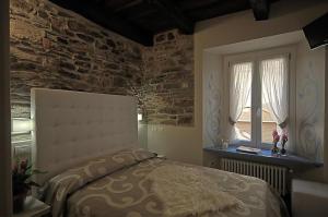 a bedroom with a bed and a brick wall at Locanda di Orta in Orta San Giulio