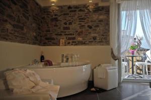 a bath tub in a room with a stone wall at Locanda di Orta in Orta San Giulio