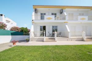 Cette maison blanche dispose d'un balcon et d'une cour. dans l'établissement Vila Guerreiro, à Olhos de Água