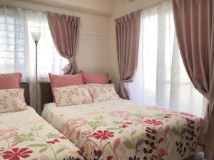 a bedroom with two beds and a window at TerraceRin YN23 in Tomigusuku
