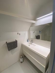 Baño blanco con lavabo y espejo en Aan de Vecht en Nederhorst den Berg