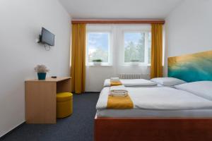 
a bedroom with a bed and a desk at Atlas Hotel Garni in Prague
