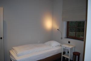 a small bed in a room with a small table at Orshof in Oudsbergen 