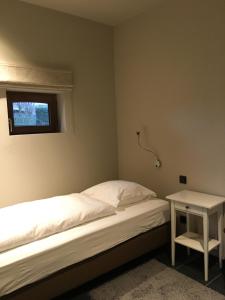 a small bedroom with a bed and a small table at Orshof in Oudsbergen 