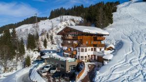 a large building in the snow on a mountain at Appartement-Gästehaus Marie Anderl in Saalbach Hinterglemm