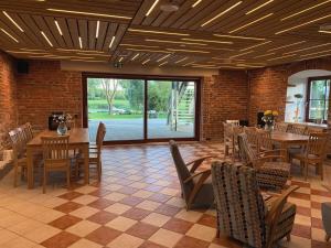 a dining room with tables and chairs and a brick wall at Riverside Villa in Luunja
