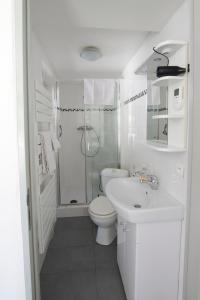 a white bathroom with a toilet and a sink at Chambr'im Leh in Hoerdt